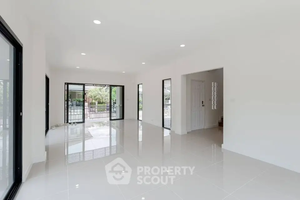 Spacious modern living room with large windows and glossy tile flooring