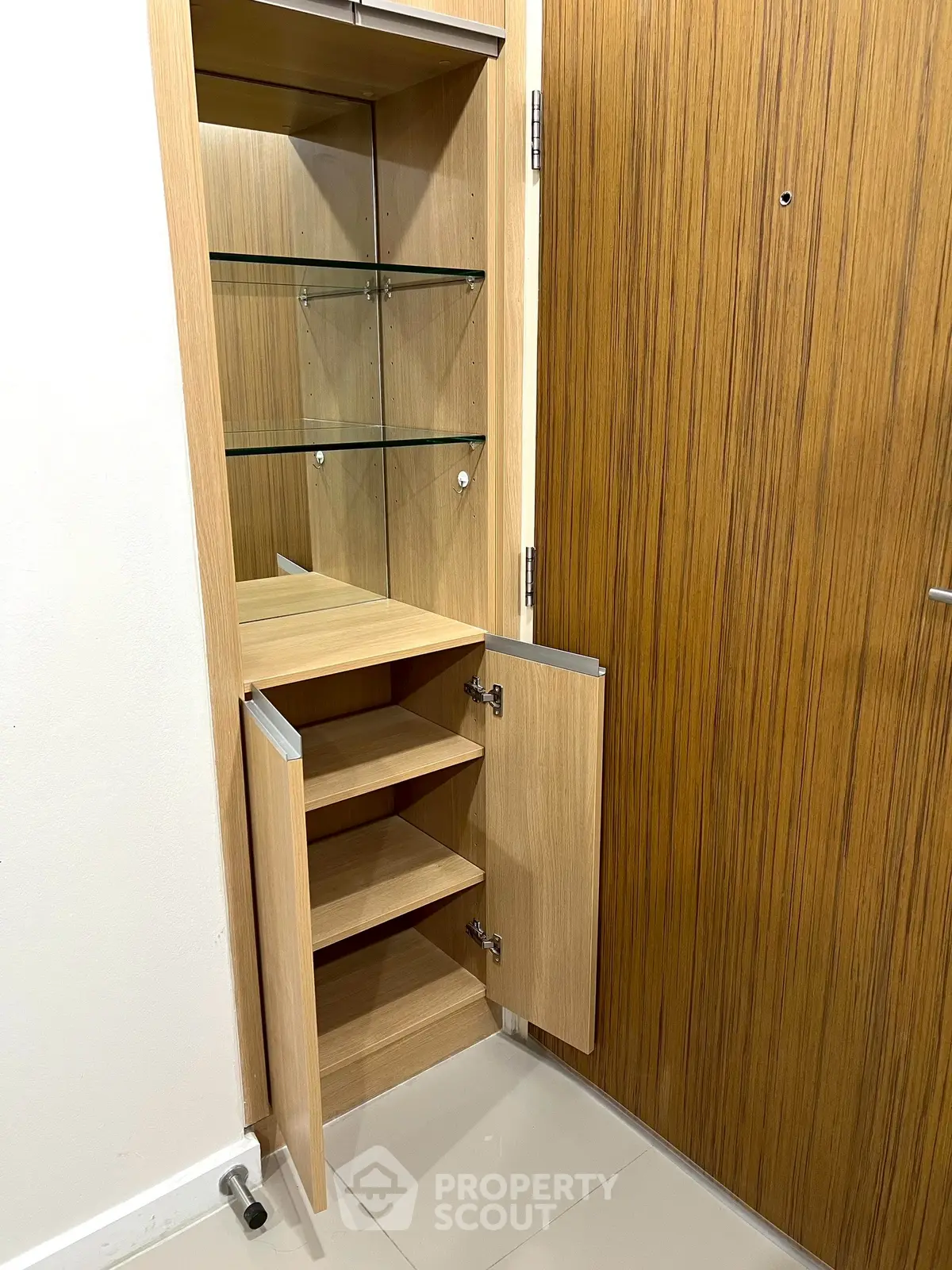 Modern wooden storage cabinet with glass shelves in a sleek interior setting.