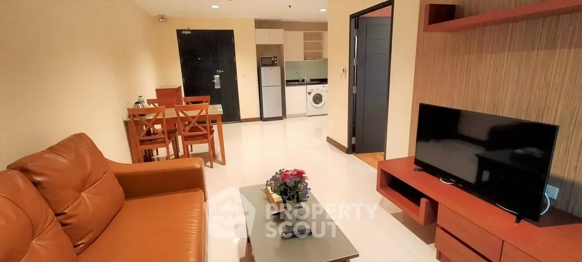 Cozy living room with modern furniture and open kitchen layout in a stylish apartment.