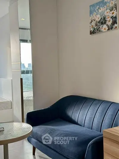 Cozy living room with blue sofa and modern decor, perfect for relaxation.