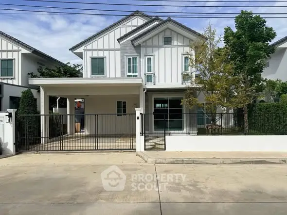 Charming two-story house with modern facade and spacious driveway in a serene neighborhood.