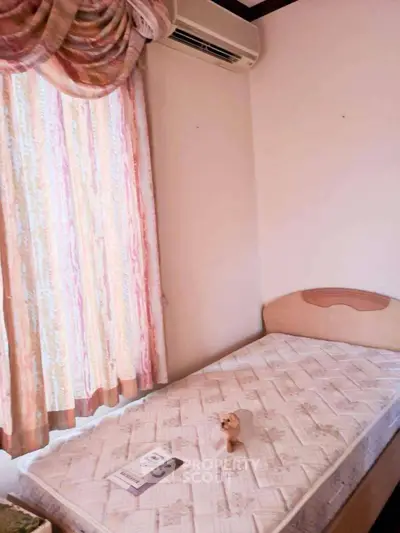Cozy bedroom with single bed and air conditioning, ideal for compact living spaces.