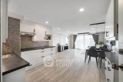 Spacious open-plan kitchen and living room with modern decor and ample natural light.