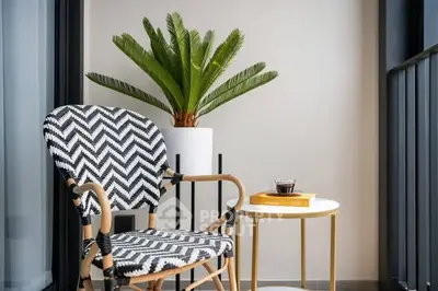 Stylish balcony with chic chair and potted plant, perfect for relaxation.