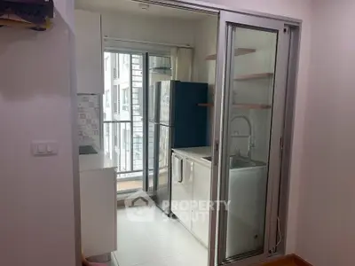 Modern compact kitchen with sliding glass door and balcony view