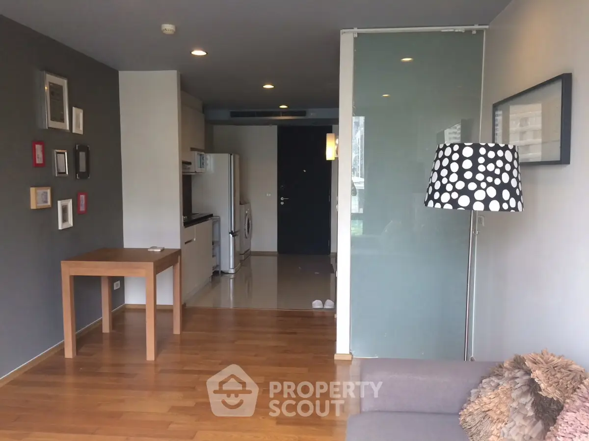 Modern living room with stylish decor and open kitchen layout in a cozy apartment.