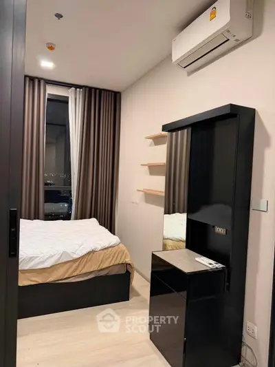 Modern bedroom with sleek furniture and city view, featuring air conditioning and stylish decor.