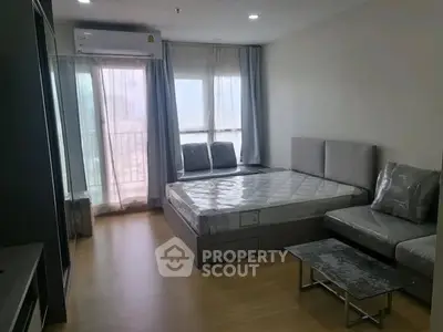 Modern bedroom with natural light and minimalist decor in urban apartment.