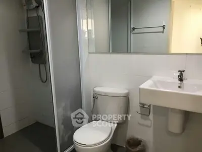 Modern bathroom with shower, toilet, and sink in a sleek design.