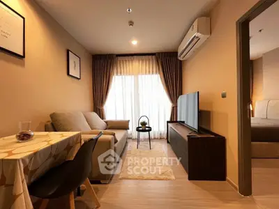 Cozy living room with modern decor, featuring a comfortable sofa, flat-screen TV, and elegant curtains.