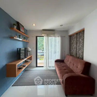 Modern living room with stylish sofa, wall-mounted TV, and balcony view.
