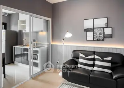 Modern living room with sleek kitchen and stylish decor in open layout apartment.