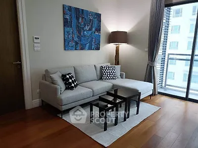 Modern living room with stylish decor and large windows offering city views.