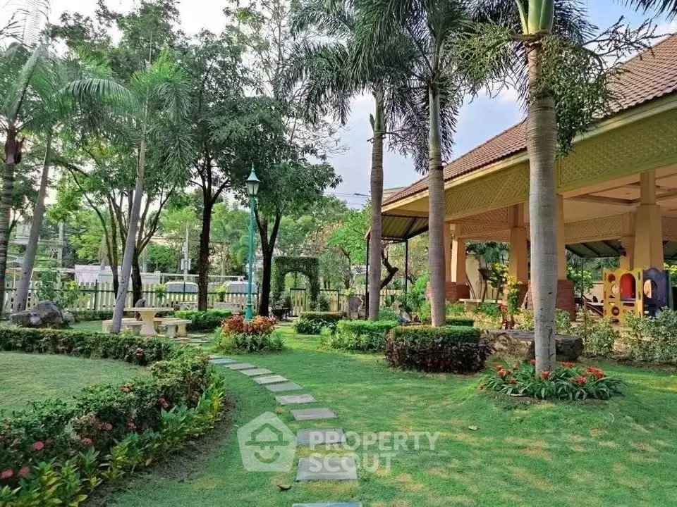 Beautiful garden with lush greenery and a charming pathway leading to a cozy outdoor pavilion.