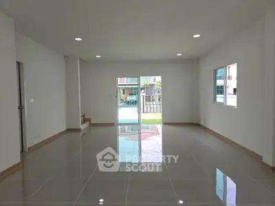 Spacious modern living room with glossy tile flooring and large windows.