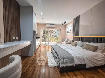 Spacious modern bedroom with elegant decor and large windows offering natural light.