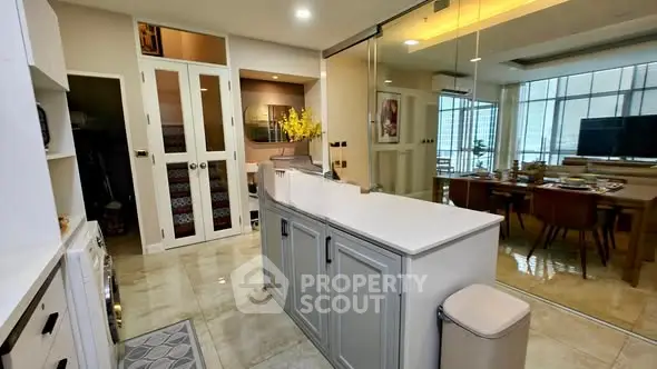 Modern open-plan kitchen with sleek cabinetry and dining area in a stylish apartment.