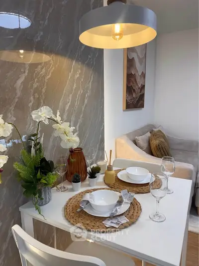 Chic dining area with elegant table setting and cozy seating in modern apartment.