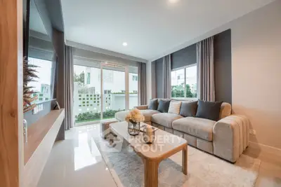 Modern living room with large windows and cozy seating area