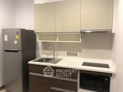 Modern kitchen with sleek cabinetry and appliances in a compact layout.