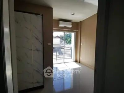 Bright room with large window and air conditioning, featuring a sleek modern wardrobe.