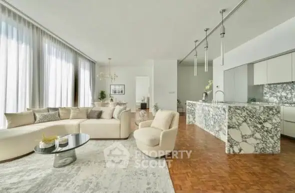 Luxurious open-plan living room with elegant marble kitchen island and chic furnishings.