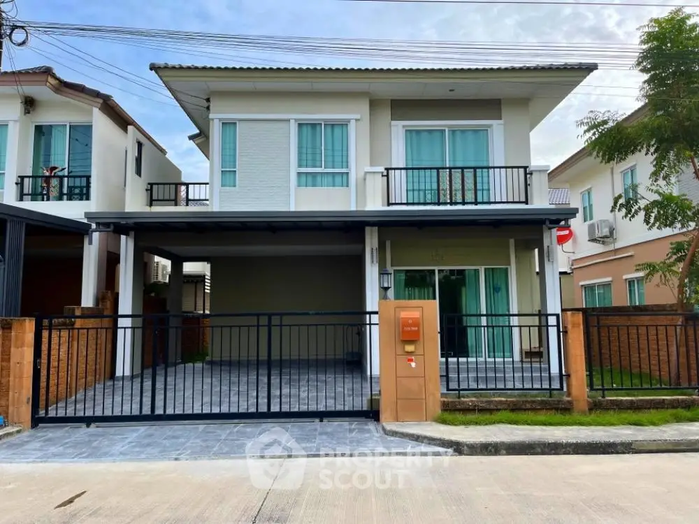 Charming two-story home with spacious balcony and secure carport, nestled in a serene neighborhood, boasting modern design and lush greenery.