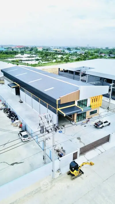 Modern industrial building with spacious parking and sleek design, ideal for business operations.
