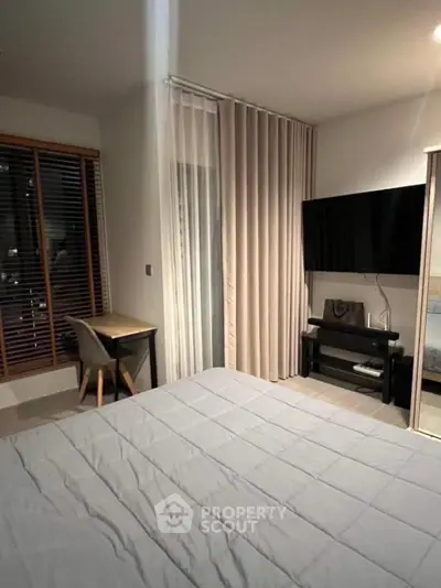 Modern bedroom with sleek decor and large TV, perfect for relaxation and entertainment.
