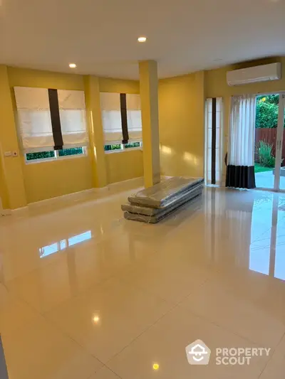 Spacious living room with large windows and modern tile flooring