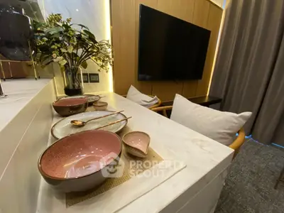Modern living room with stylish decor and wall-mounted TV, featuring elegant dining setup.