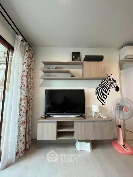 Modern living room with stylish TV unit and zebra wall art, featuring elegant decor and natural light.