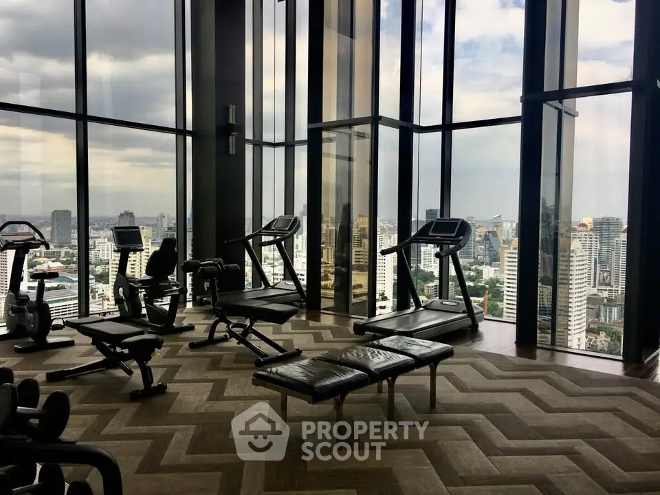 Luxurious high-rise gym with panoramic city views and modern fitness equipment.