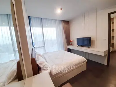 Modern bedroom with city view, featuring sleek furniture and large windows for natural light.