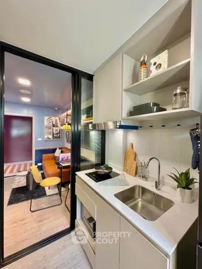 Modern compact kitchen with sleek design and open layout leading to stylish dining area.