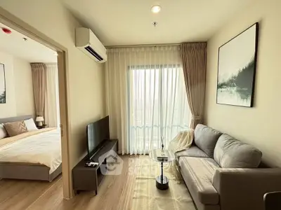 Modern living room with cozy sofa, TV, and large window leading to a bedroom, perfect for urban living.