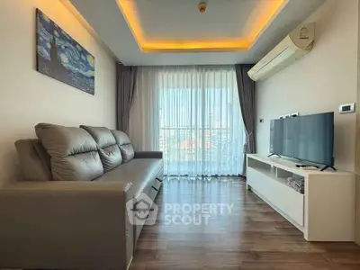 Modern living room with sleek furniture and large window offering natural light.