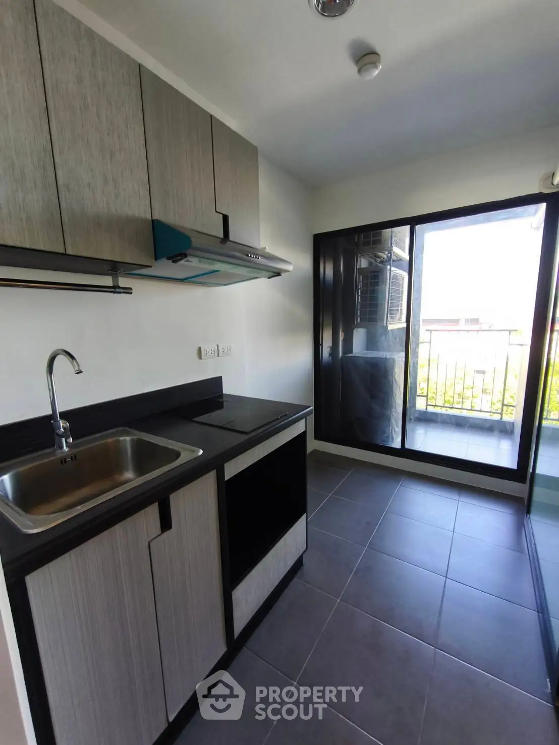 Modern kitchen with sleek cabinetry and balcony access in a stylish apartment.