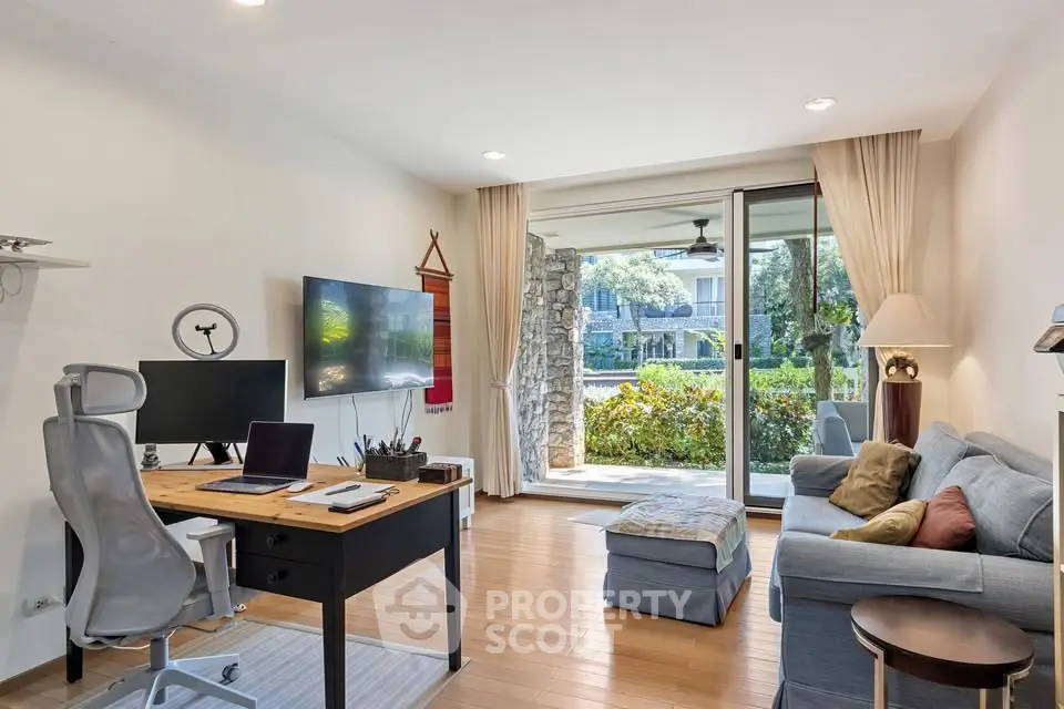 Modern living room with home office setup and garden view, featuring stylish furniture and natural light.