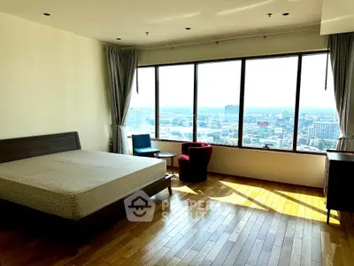 Spacious bedroom with panoramic city view and elegant wooden flooring