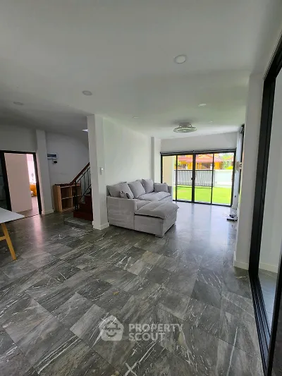 Spacious modern living room with large windows and stylish gray flooring