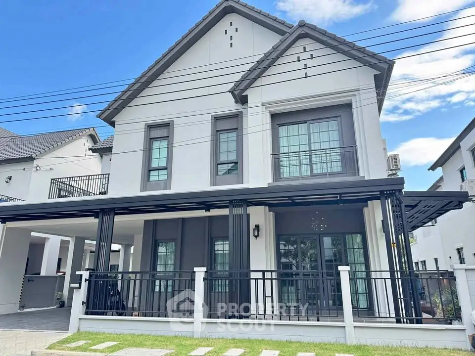 Modern two-story house with sleek design and spacious balcony, perfect for family living in a serene neighborhood.