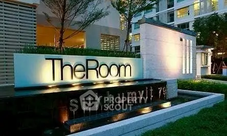Modern condominium entrance with illuminated signage at The Room Sukhumvit 79.