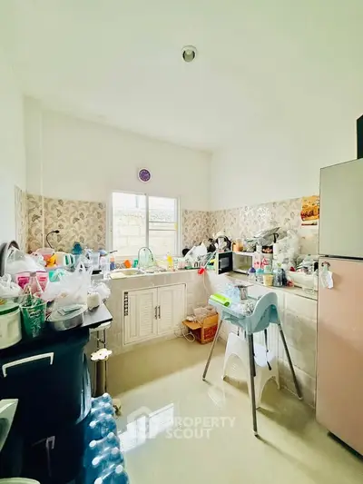 Cozy kitchen with ample storage and natural light, featuring modern appliances and a clean design.