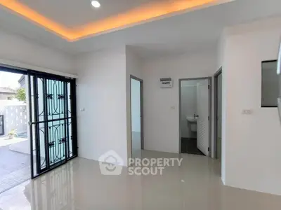 Modern interior with sleek tile flooring and recessed lighting, featuring a view of the patio through glass doors.