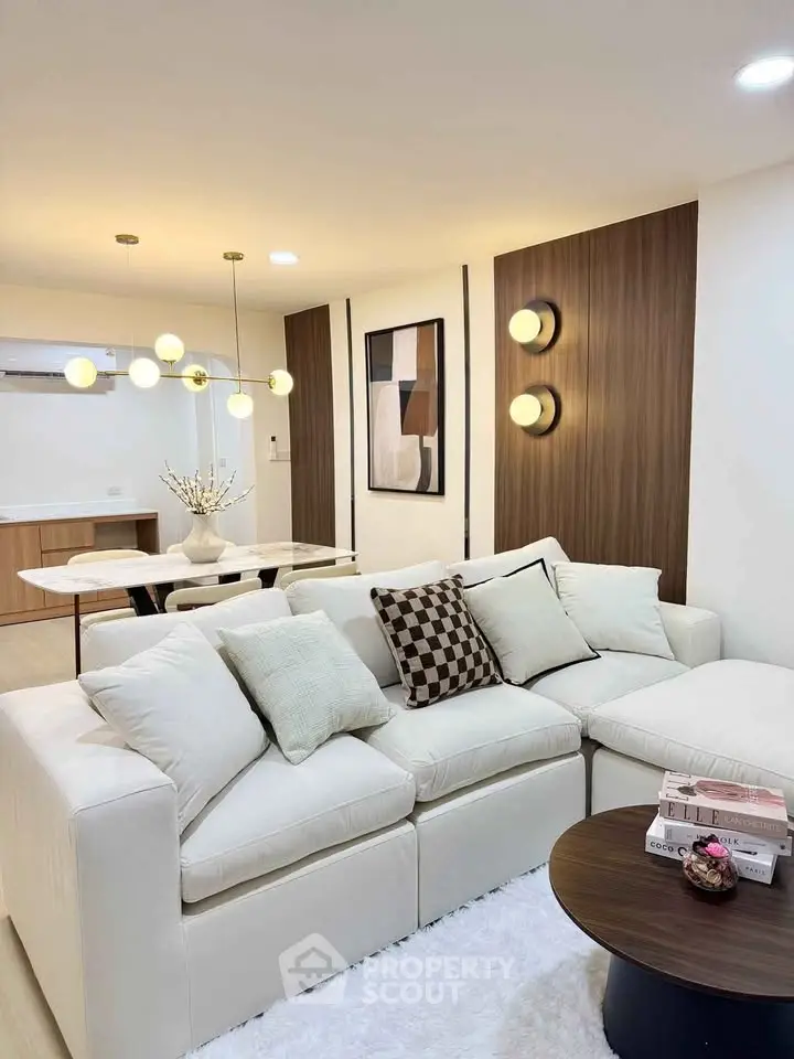 Elegant modern living room with plush white sofa and stylish lighting in a contemporary apartment.