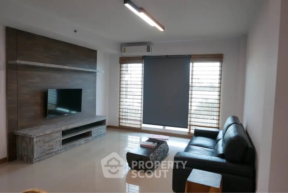 Modern living room with sleek furniture and large windows for natural light.