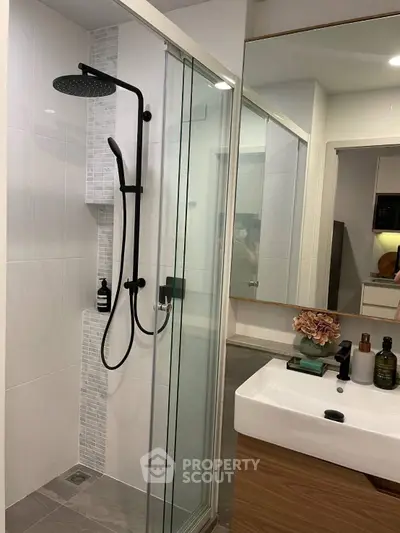 Modern bathroom with sleek shower and stylish vanity in contemporary apartment.