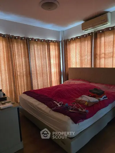 Cozy bedroom with natural light and modern air conditioning unit.