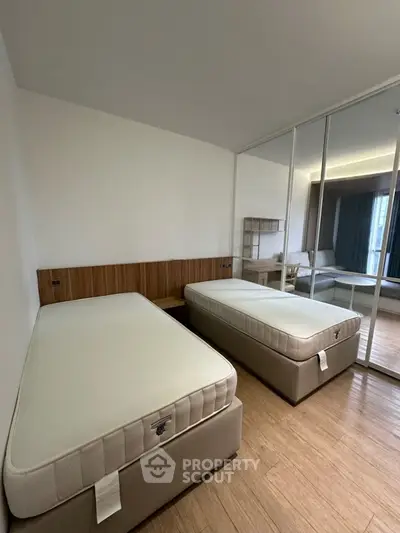Spacious bedroom with twin beds and mirrored closet in modern apartment
